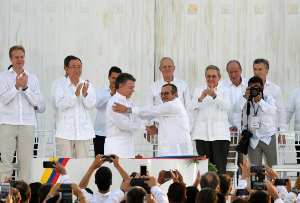 943949-le-president-colombien-juan-manuel-santos-g-au-centre-serre-la-main-du-chef-des-farc-timoleon-jimene